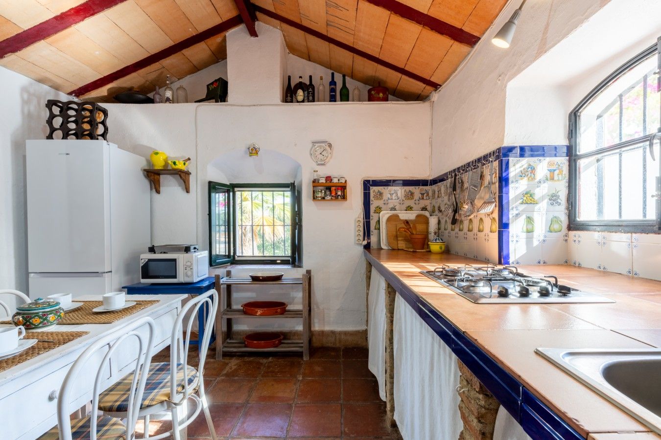 Cocina compacta con microondas, estufa y ventana con vistas.