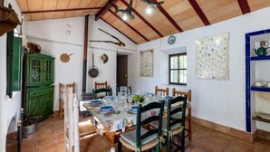 Un comedor con una mesa de madera dispuesta para cuatro personas, rodeado de sillas.