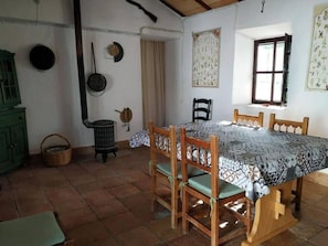 Un espace repas comprenant une table, des chaises, une fenêtre et une porte.