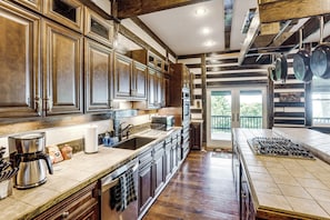 A spacious kitchen with wooden cabinets, a large island, and a view to the outside. - Shenandoah NP Escape w/ Deck: Hike, Soak + Fish (Stanley)