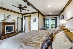 A bedroom with a large bed, a fireplace, a ceiling fan, and a view of the outdoors. - Shenandoah NP Escape w/ Deck: Hike, Soak + Fish (Stanley)