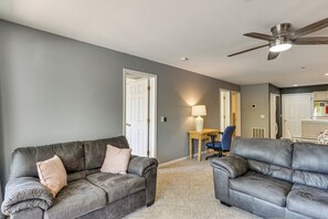 A living room with two grey sofas, a ceiling fan, and a lamp. - Unwind Poolside, Walk to Beach! Ozarks Getaway (Osage Beach)