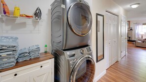 Un espace buanderie comprenant des paniers à linge, un lave-linge et un sèche-linge.