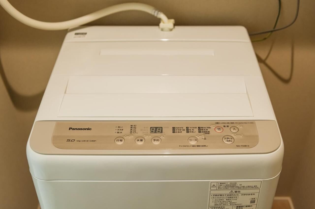 A white Panasonic 5.0 dryer with a control panel, a power cord, and a label with safety warnings.