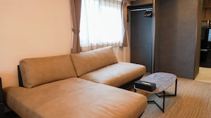 A modern room with a beige sofa, a small coffee table, and a wardrobe. - INNEST HAKATA (Fukuoka City)