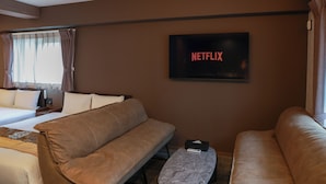 A hotel room with a bed, two sofas, a TV displaying 'NETFLIX,' and a window with curtains. - INNEST HAKATA (Fukuoka City)