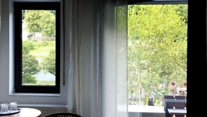 A room with a window, a chair, and a table.