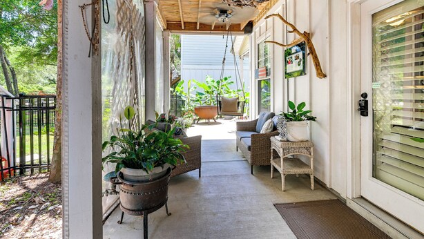 A covered porch with wicker furniture, potted plants, and a ceiling fan. - Walk to the Water! Murrells Inlet Getaway (Murrells Inlet)