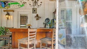A bar area with wooden stools, a chandelier, and a wall-mounted fish decoration. - Walk to the Water! Murrells Inlet Getaway (Murrells Inlet)