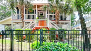 A two-story house with a porch, a staircase, and a fenced yard. - Walk to the Water! Murrells Inlet Getaway (Murrells Inlet)