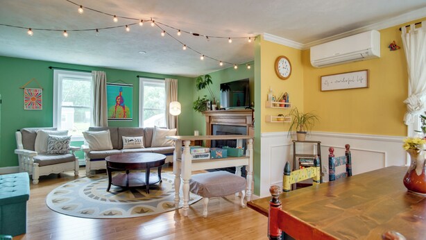 Una sala de estar con sofá, sillón, mesa de centro y chimenea.