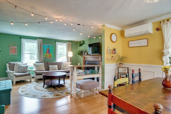A living room with a sofa, armchair, coffee table, and a fireplace. - Family Mashpee Eco-Retreat - Naturally Cape Cod! (Mashpee)
