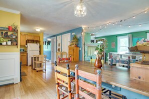 A kitchen with wooden cabinets, a wooden dining table, and string lights. - Family Mashpee Eco-Retreat - Naturally Cape Cod! (Mashpee)