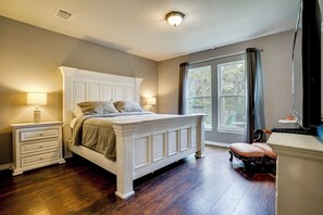 A bedroom with a large bed, bedside tables, a chair, and a window. - Walk to Lake Granbury: Home w/ Fire Pit! (Granbury)