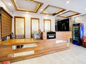 A reception desk with a sign reading 'TOWNHOUSE,' a printer, and a vending machine. - Super Deluxe Room Aashima Mall (Bhopal)