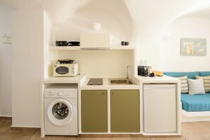 A compact kitchenette with a washing machine, a microwave, a sink, and a small refrigerator. - Little Garden Suite, Kaminia Holiday Homes (Exo Gonia)