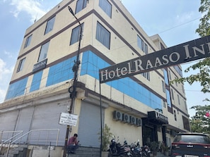 Um hotel de vários andares com uma placa que diz 'Hotel Raaso Inn'.