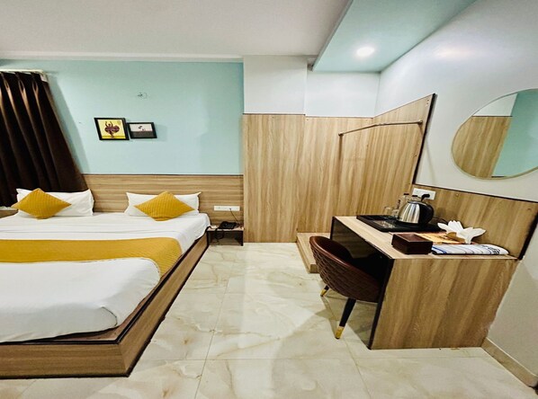Ein Hotelzimmer mit Bett, Nachttisch, Schreibtisch, Stuhl und Spiegel.