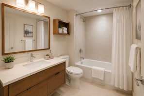 A modern bathroom with a sink, toilet, and bathtub. - Solara & Slate Hotel (Toronto)