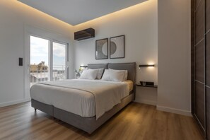 A modern bedroom with a large bed, a ceiling fan, and a view of the city. - Spefsippou37·Kolonaki Skyline Views (Athens)