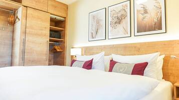 Ein Hotelzimmer mit einem großen Bett, einem Holzschrank und drei gerahmten Bildern an der Wand.