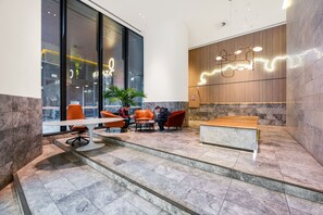Eine moderne Lobby mit Empfangstresen, Sitzgelegenheiten und großen Fenstern.