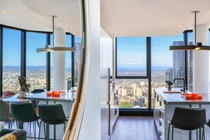 Eine moderne Küche mit großen Fenstern, einem Essbereich und Blick auf die Stadt.