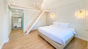 Un dormitorio con cama, una escalera, un armario y una lámpara fijada a la pared.