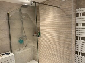 A modern bathroom with a glass-enclosed shower, a white vanity with drawers, and a tiled wall. - Beautiful apartment in downtown Annecy (Annecy)