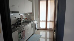 Uma cozinha moderna com m áquina de lavar embutida, cafeteira e pia.