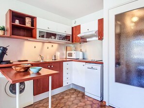 A compact kitchen with a washing machine, a microwave, and a dishwasher. - Le Clos des Pecheurs by Interhome (Six Fours)