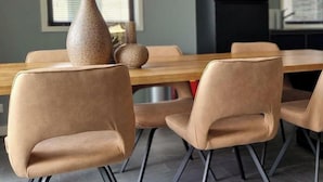 En matplats med ett träbord och fyra beige stolar.