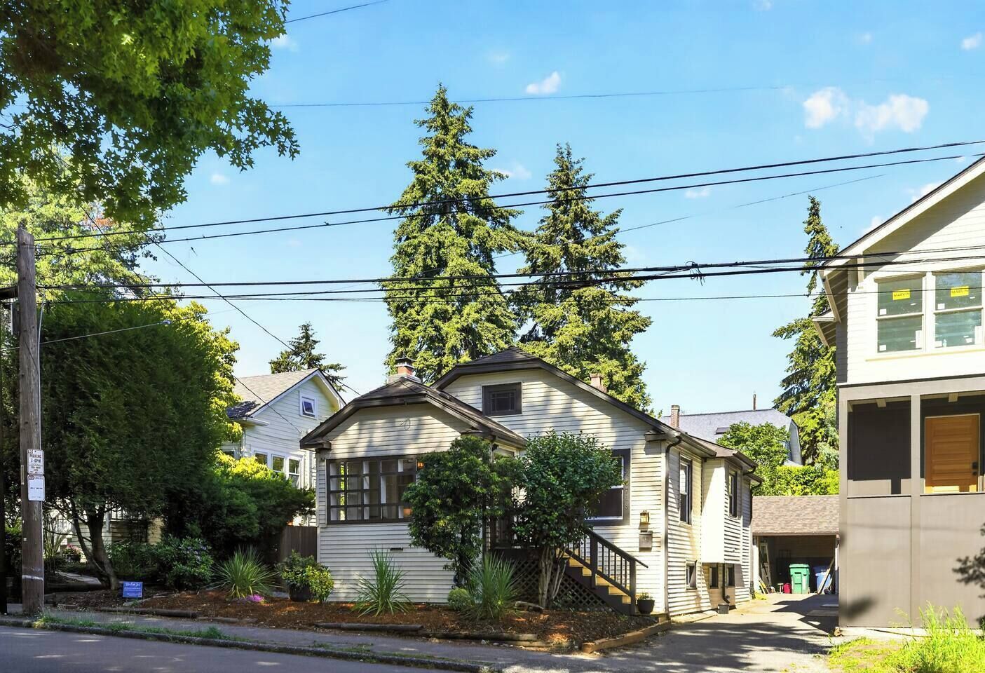 A two-story house with a front porch, a small front yard, and a garage.