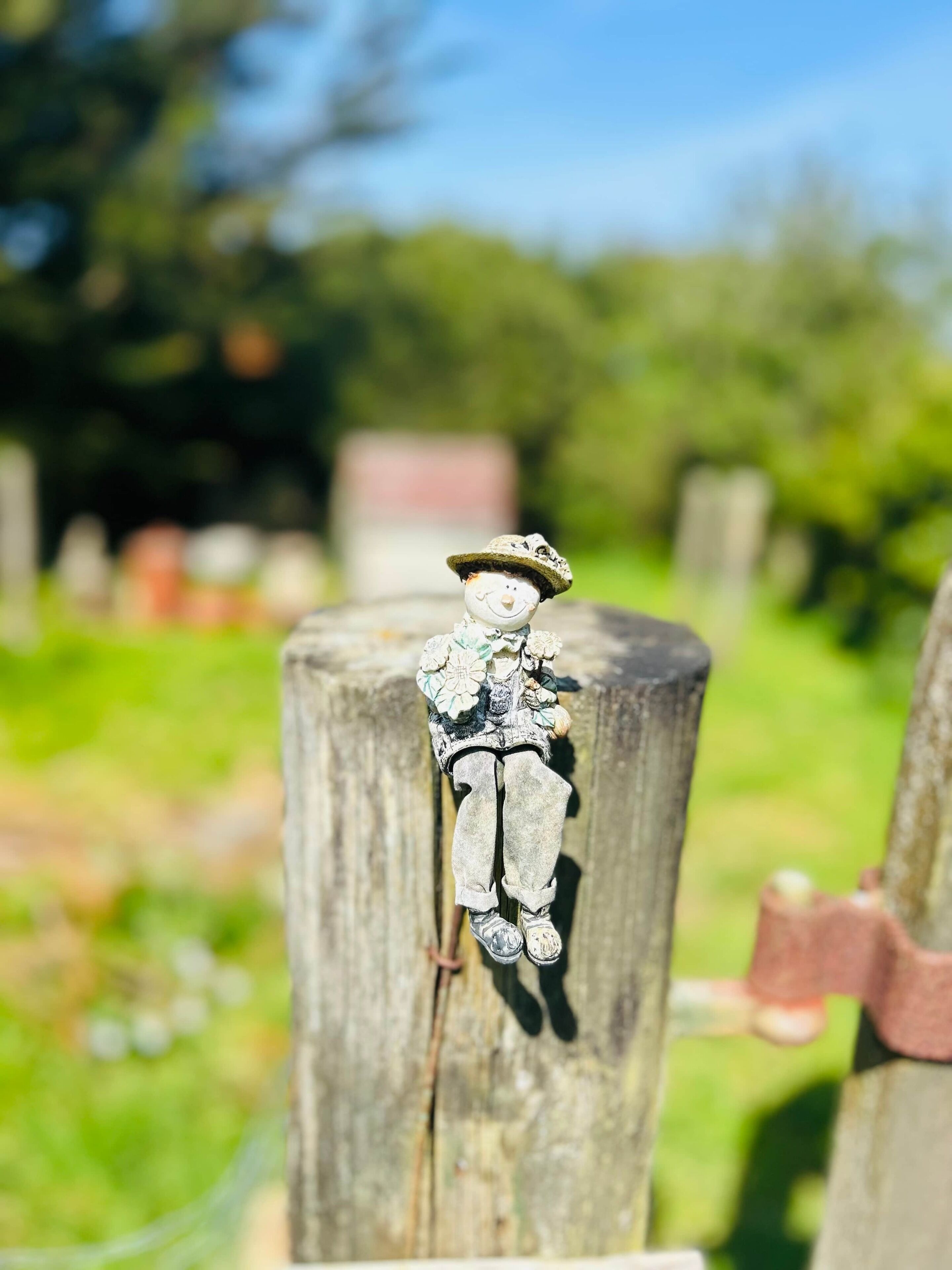 Un poste de madera rústica con una pequeña figura de una persona sentada.