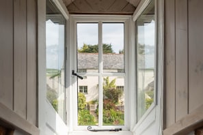 Ein Fenster mit Blick auf ein Gebäude und einen Garten.