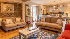 A living room with two sofas, a coffee table, and a kitchen in the background. - Dollys Barn - Ilfracombe (Near Woolacombe) (Ilfracombe)