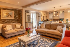 Ein Wohnzimmer mit zwei Sofas, einem Couchtisch und einer Küche im Hintergrund.