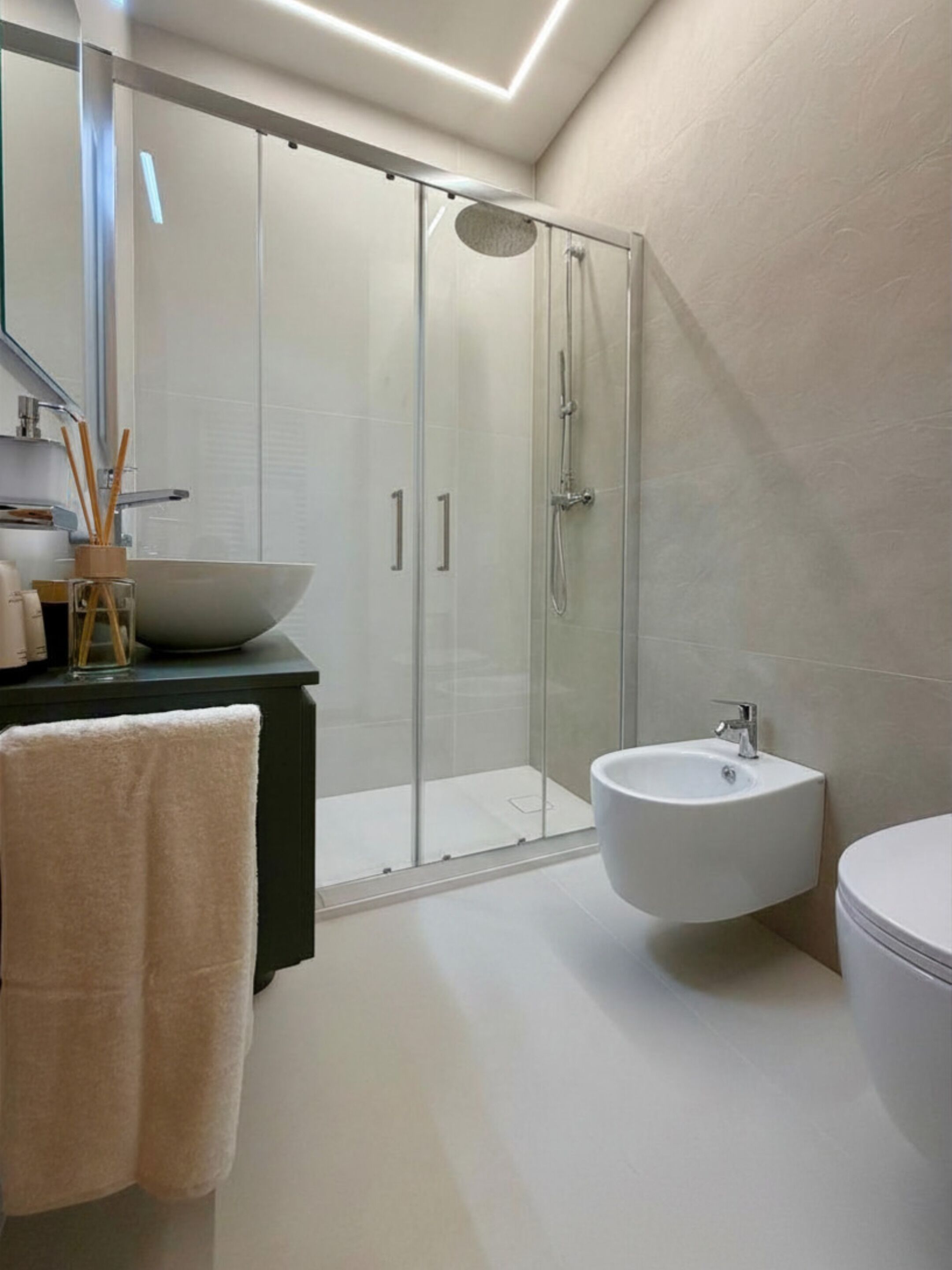 Une salle de bain moderne avec une douche à parois de verre, un grand lavabo et des toilettes.