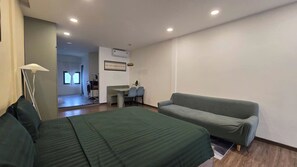 Um quarto com uma cama, um sofá, uma escrivaninha e uma cadeira.