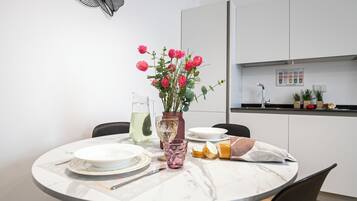 Ein Esstisch mit Tellern, einer Karaffe, einer Vase mit Blumen und einem Glas.