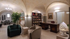 Amplia sala de estar con un techo alto abovedado, una gran estantería, un escritorio y un espacio de descanso acogedor.
