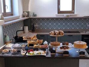 Una encimera de cocina con diversas preparaciones horneadas y un pastel.