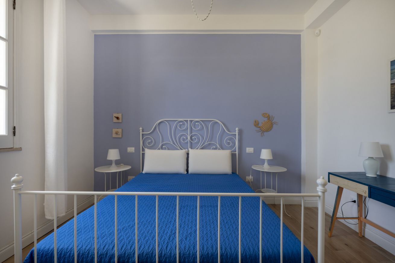 Une chambre à coucher avec un lit, deux tables de chevet, un bureau et une chaise.