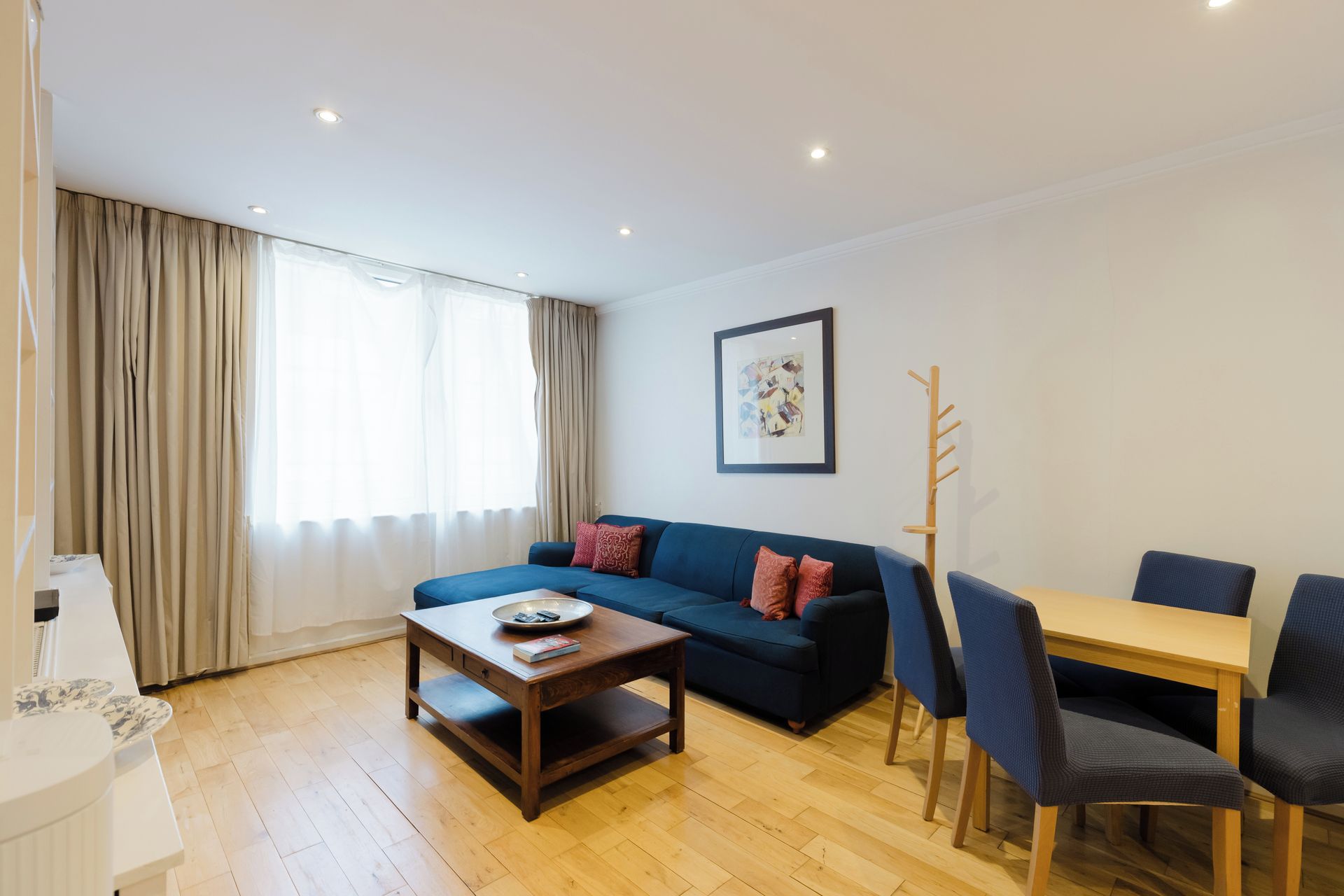 Una sala de estar moderna con sofá, mesa de centro y comedor.