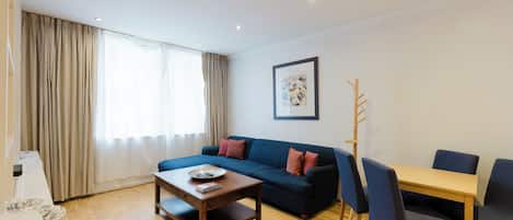 Una sala de estar moderna con sofá, mesa de centro y comedor.