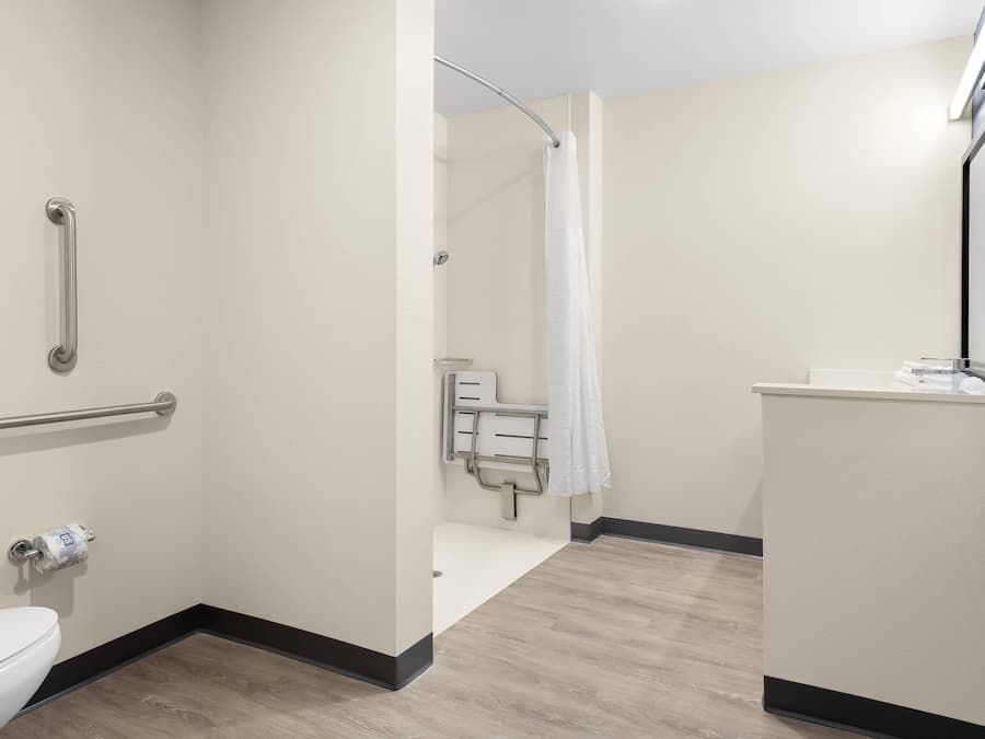 A bathroom with a toilet, a shower with a glass door, and a sink with a towel rack.