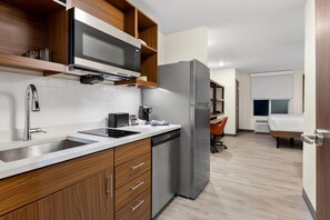 A modern kitchen with stainless steel appliances, wooden cabinets, and a dishwasher.
