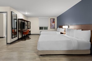 Una habitación de hotel con una cama grande, un escritorio con computadora y televisión.