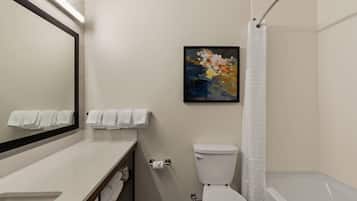 A bathroom with a toilet, sink, mirror, and shower curtain.