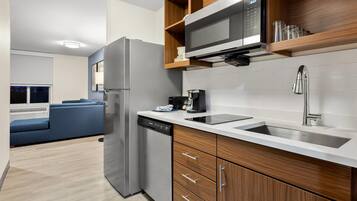 A modern kitchen with a built-in microwave, a dishwasher, and a stainless steel sink.